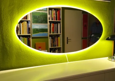 Ovaler Flurspiegel mit LED-Beleuchtung über maßgefertigtem Möbel