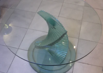 Runder Glastisch mit spiralförmigem Glasgestell in einem Innenraum in Grünwald bei München