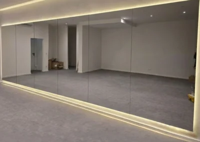 Große maßgefertigte Spiegelwand in einem Yoga-Studio in der Münchner Altstadt mit indirekter LED-Beleuchtung