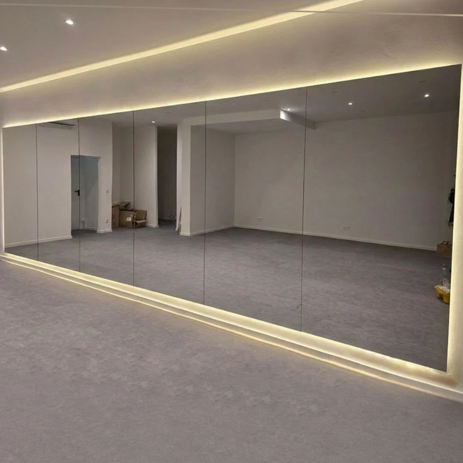 Große maßgefertigte Spiegelwand in einem Yoga-Studio in der Münchner Altstadt mit indirekter LED-Beleuchtung