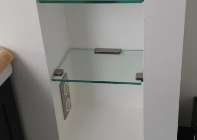 Glasablagen in einer Wandnische mit Metallhalterungen.