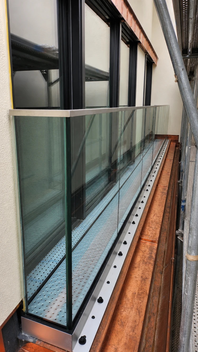 Maßgefertigtes Glasgeländer an einer Dachaufstockung in München-Maxvorstadt.