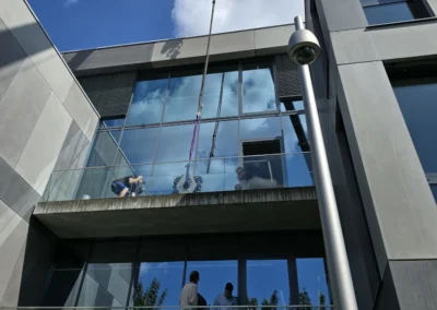 Monteure arbeiten an einer modernen Glasfassade eines Wohn- oder Gewerbegebäudes.