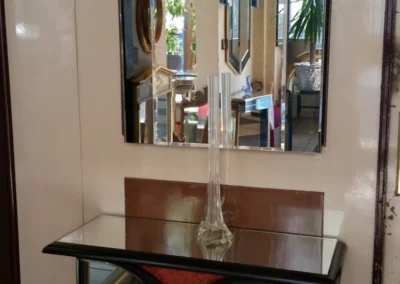 Spiegelmöbel mit Wandspiegel und Glasplatte in einem Eingangsbereich.