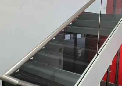 Treppengeländer aus Glas mit Edelstahlhandlauf im Innenbereich.