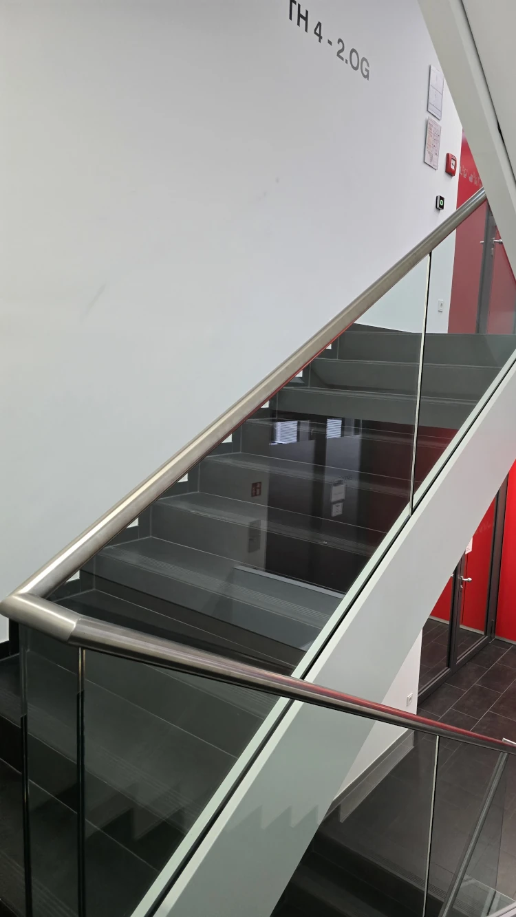 Treppengeländer aus Glas mit Edelstahlhandlauf im Innenbereich.