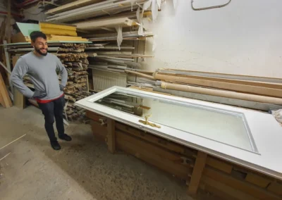 Spiegeltür mit Glaseinsatz liegt zur Bearbeitung in einer Glaswerkstatt.